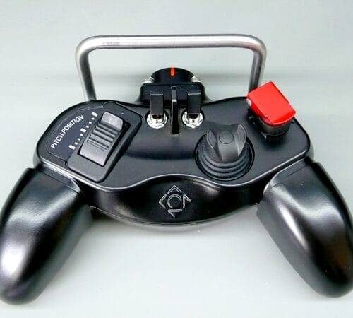 Svart fjärrkontroll med röda och svarta knappar.