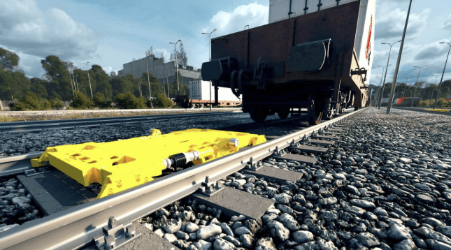 Gult maskineri på järnväg med järnvägsvagn