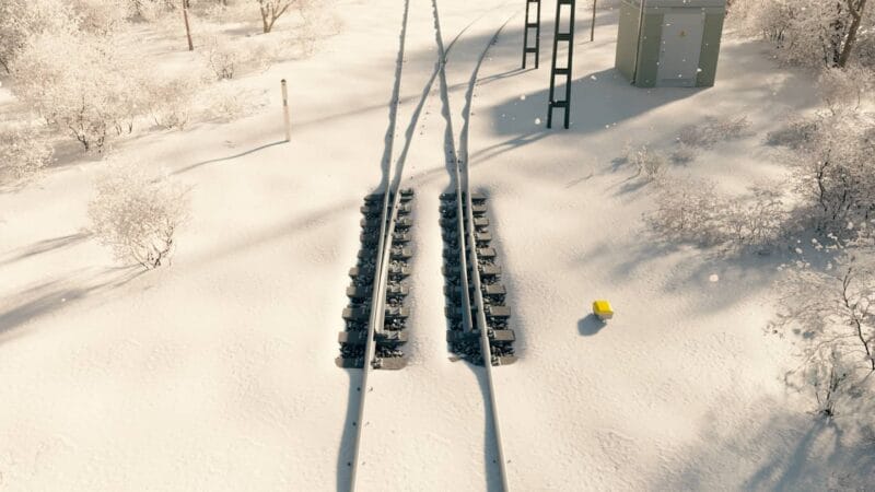 Snöig järnväg i vinterskogsmiljö.