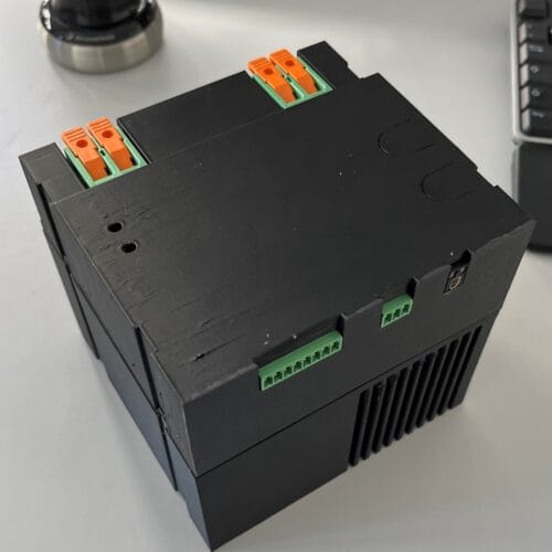 Svart industriell elektronikmodul med gröna kontakter