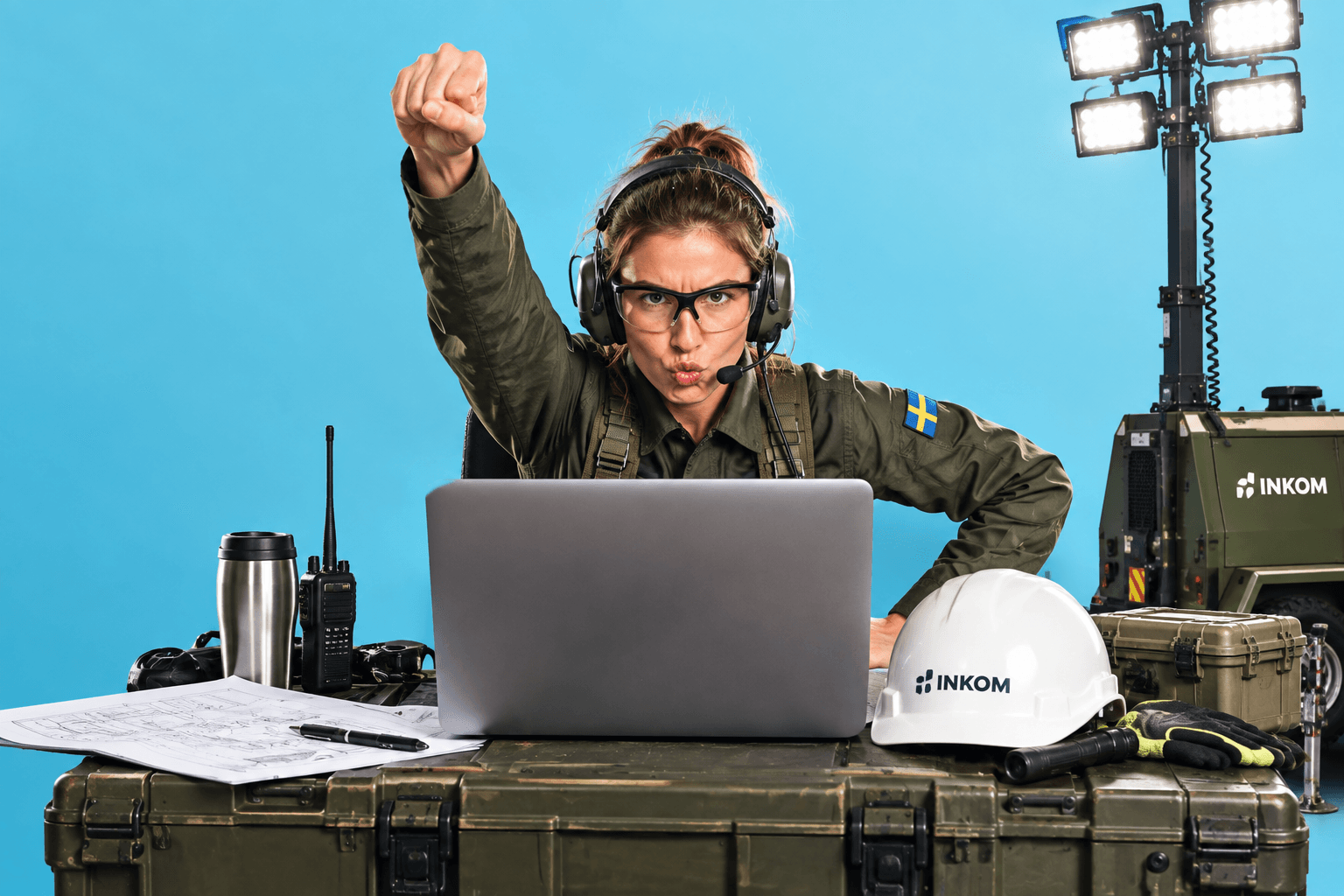 Kvinnlig operatör vid laptop med svensk flagga på uniformen