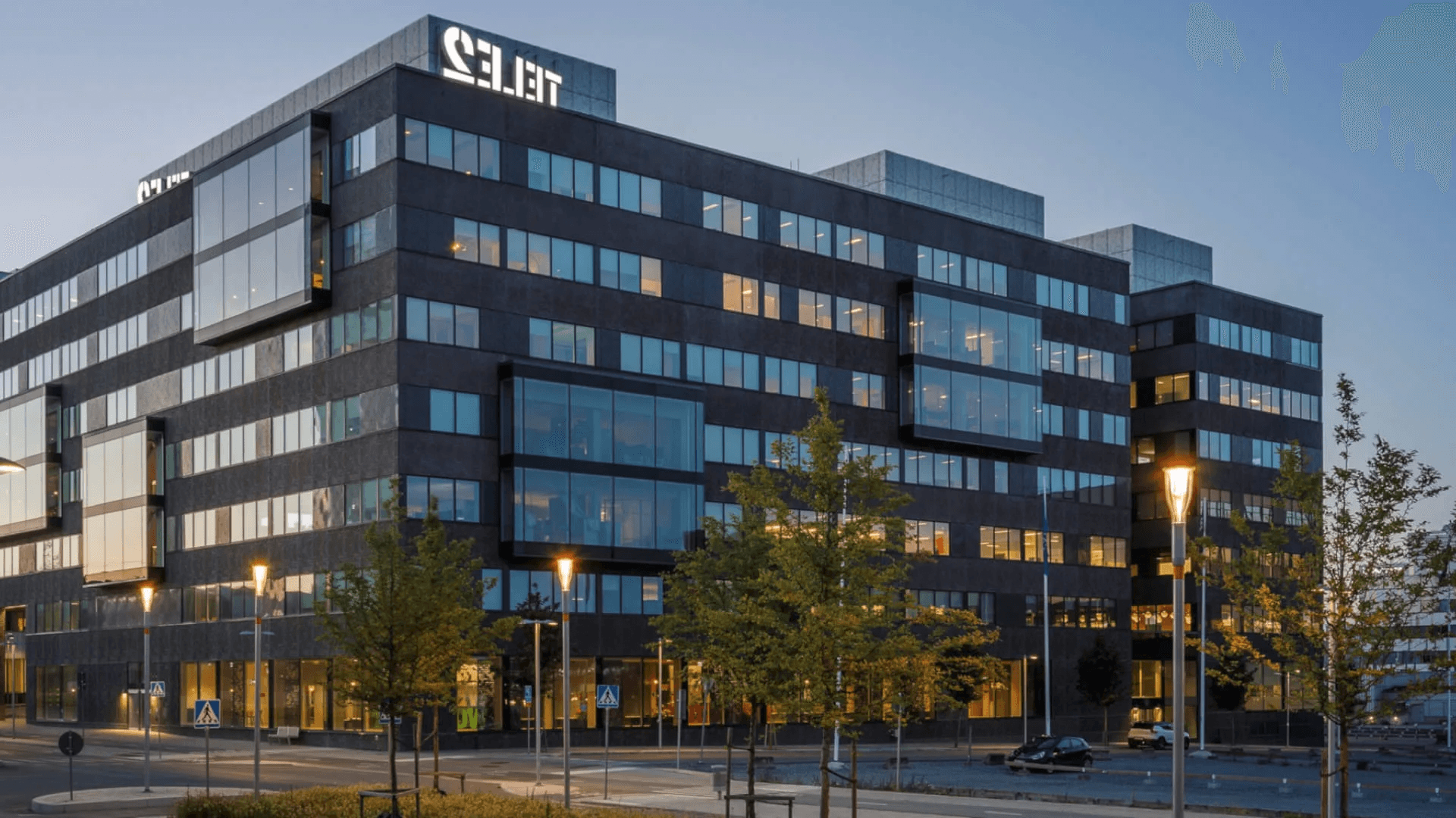 Modern kontorsbyggnad med Select-skylt i kvällsljus.